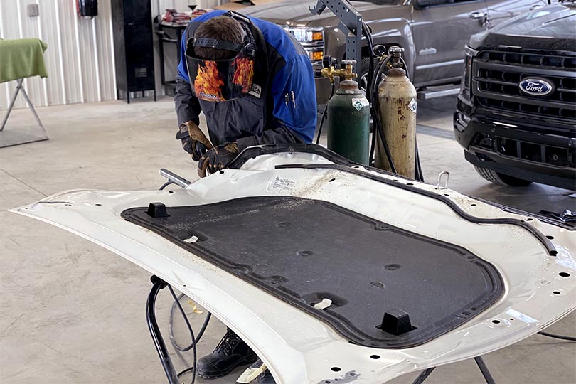 Wheaton Collision team member welding car panel